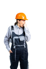 Young beautiful woman engineer in a protective uniform bites her fist from fear. Isolated