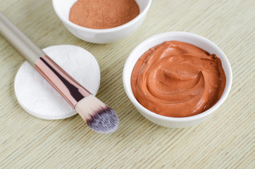 Small white bowl with red cosmetic clay mask. Homemade beauty treatment. Copy space.