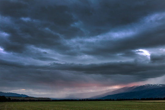 Tarras New Zealand coast. Thunder and rain clouds at twilight © A