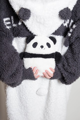 もこもこの部屋着でパンダのぬいぐるみを持つ女性　縦写真