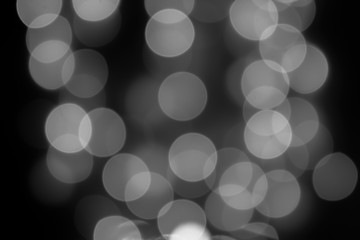 Defocus blurred circles from electric bokeh lamps, background backdrop decoration design. Black and white blurred light effect of blurry glare of light spots