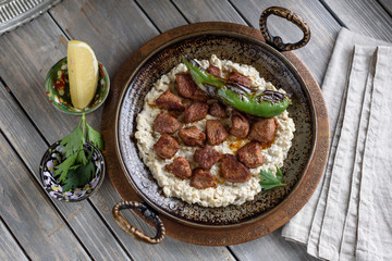 Turkish Sauteed Lamb Meat Served with Smoked Eggplant and Yogurt Puree, Garnished with Grilled Hot Pepper. Ali Nazik Kebab