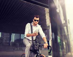Fototapeta na wymiar lifestyle, transport, communication and people concept - young man with bicycle and smartphone on city street