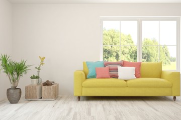 Stylish room in white color with sofa and summer landscape in window. Scandinavian interior design. 3D illustration