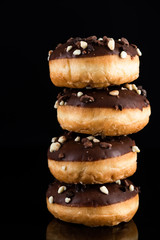 Chocolate Donuts or Doughnuts Tower on Dark Background. Copy Space for Text