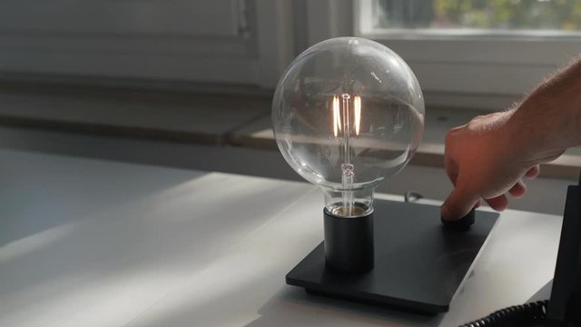 Hand switching on a LED light bulb
