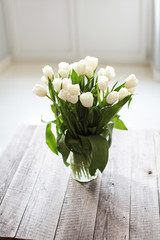 bouquet of white tulip flowers on wooden table