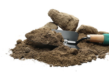 Dirt, soil pile and chunks with gardening trowel, shovel for planting isolated on white background