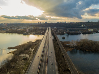 Aerial drone view. Darnitsky railway-automobile bridge in Kiev in the sunset light.