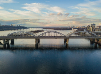 Fototapeta na wymiar Aerial drone view. Darnitsky railway-automobile bridge in Kiev in the sunset light.