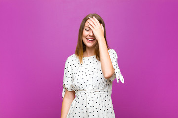 red head pretty woman laughing and slapping forehead like saying d‚Äôoh! I forgot or that was a...