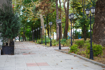 Tiled road in the Park. Grey tiles, steps, green Park in Bulgaria