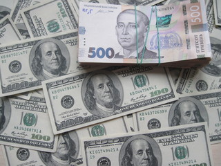 Financial background with a lot of paper banknotes of USA 100 dollars and Ukraine 500 hryvnia is great for editorial publication about money exchange.      