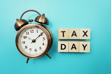 Tax Day Word alphabet letter And Alarm Clock on blue background