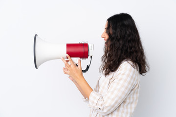 Mixed race woman over isolated white background shouting through a megaphone