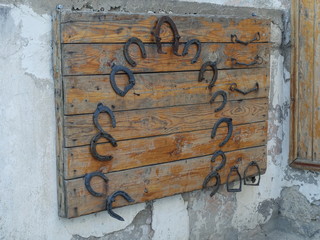 Old rusty horseshoes and stirrups on a wooden background.