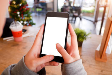 Mockup picture of business woman’s hands holding smart phone with white blank screen in modern place.