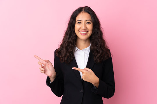 Mixed Race Business Woman Over Isolated Pink Background Pointing Finger To The Side