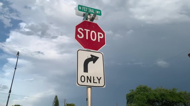 Right only turn and stop road sign on the background of cloudy sky