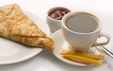 Pancake served with full cup of coffee and jam