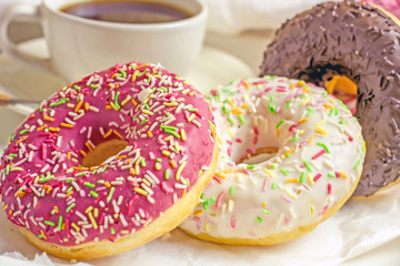  Donuts and a cup of coffee on a white table.