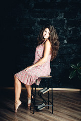 beautiful girl with magnificent hair in a summer sundress in the studio