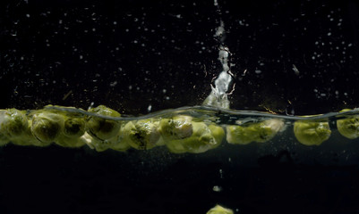 Fototapeta na wymiar Brussels sprouts falling into the water with a splash and bubbles