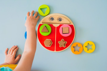 little girl collects wooden multi-colored sorter Safe natural wooden kids toys