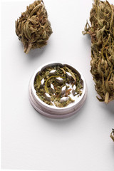 marijuana cones next to a grinder on a white background copy space