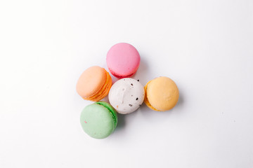 Cake macaron or macaroon on turquoise background from above, colorful almond cookies, pastel colors, vintage card, top view. Flat lay