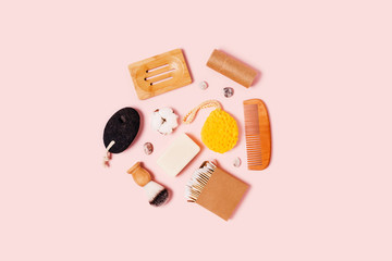 Eco-friendly accessories for women's bathroom: pumice, natural sponge, cotton swab, wooden comb, soap on a wooden stand, cotton flowers, shaving brush and natural pebbles. Flat lay, top view, copy spa