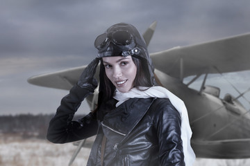 Portrait of lovely young adult woman in retro pilot costume giving military salute © Alexey Kuznetsov