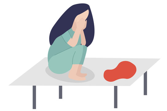 pregnancy loss, abortion, misbirth missed miscarriage. Woman is crying in hospital or clinic in hospital shirt.