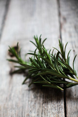 closeup of a fresh green rosemary leaves on wooden background