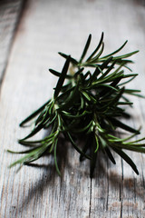 closeup of a fresh green rosemary leaves on wooden background