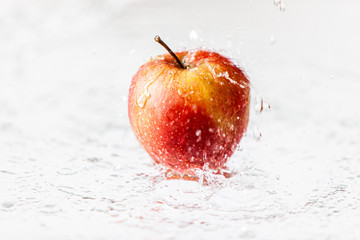 Jabłko w deszczu, polewane wodą. Widzoczne krople © andsko