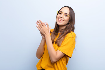 young pretty woman feeling happy and successful, smiling and clapping hands, saying congratulations...
