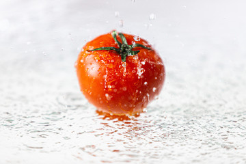 Świeży pomidor widziany z boku, polewany wodą