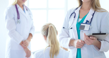 Portrait of three confident female doctors standing with arms crossed at the medical office.