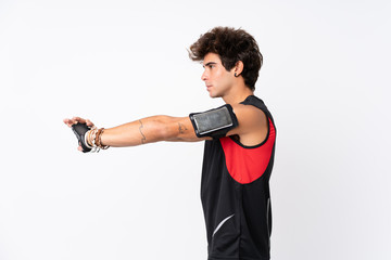 Young sport man with tattoos over isolated white background stretching arm