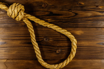 Deadly loop of rope on a wooden background. Concept of death penalty or suicide