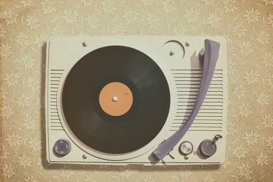 Old record player on top of flower wallpaper