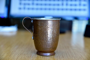 Real and pure copper mugs  of water on the table in the office