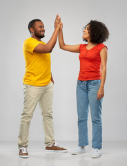 relationships and people concept - happy smiling african american couple making high five over grey background