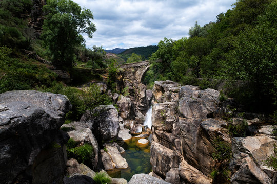 View of the ancient Mizarela Bridge (or Devil&rsquo;s Bridge) with a waterfall, at the Peneda Geres National Park, in Portugal, Europe