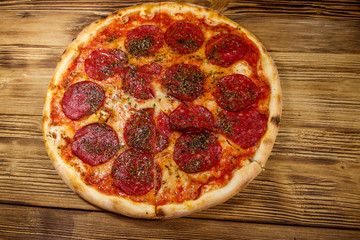 Delicious fresh pizza with sausage and cheese on a wooden table