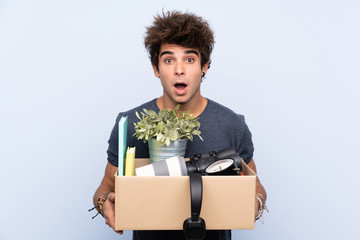Man making a move while picking up a box full of things with surprise facial expression