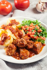 Braised pork meat stew served with potatoes