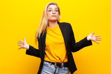 young pretty blonde woman feeling puzzled and confused, unsure about the correct answer or...