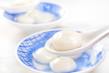 Fototapeta na wymiar Delicious tang yuan, yuanxiao in a small bowl. Asian traditional festive food rice dumplings ball with stuffed fillings for Chinese Lantern Festival, close up.